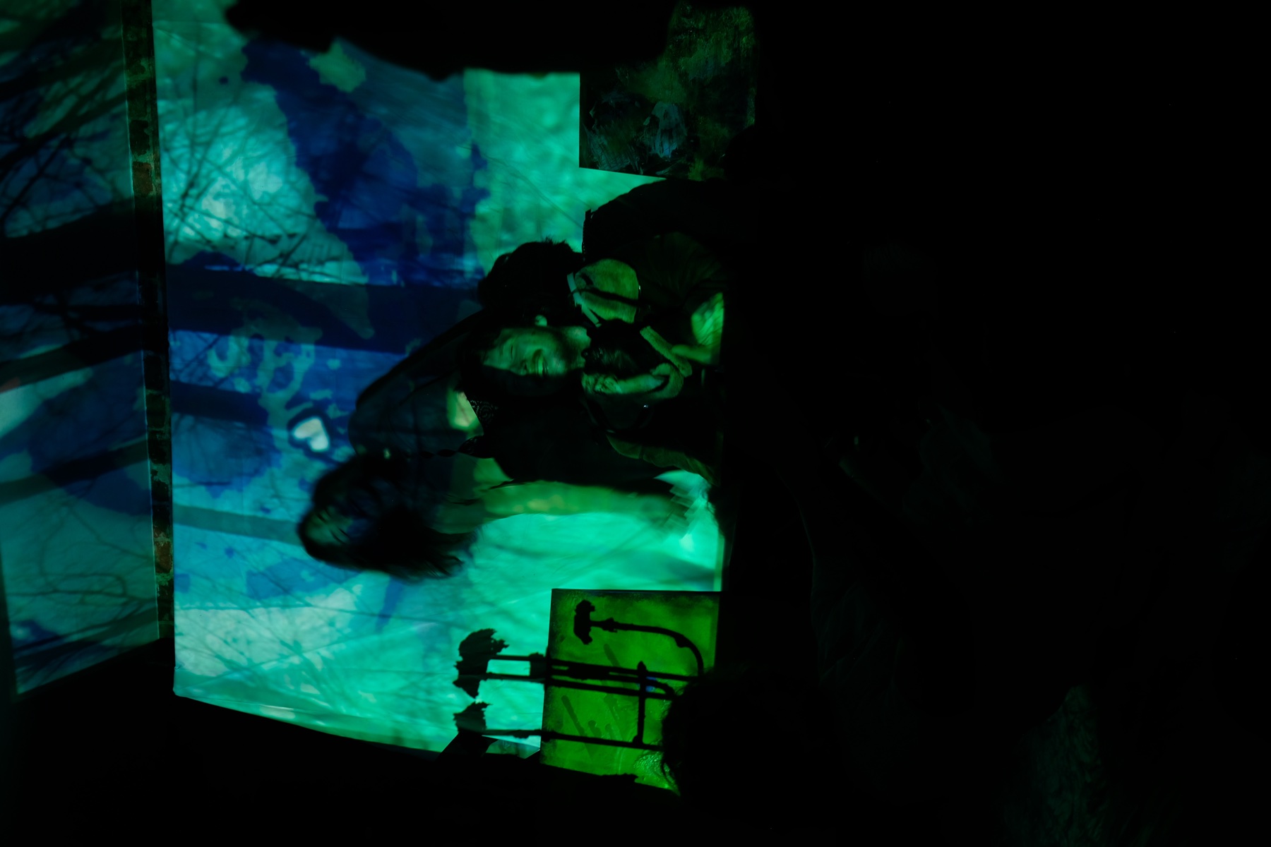 Layered green projection over two performers at TheFool Berlin.